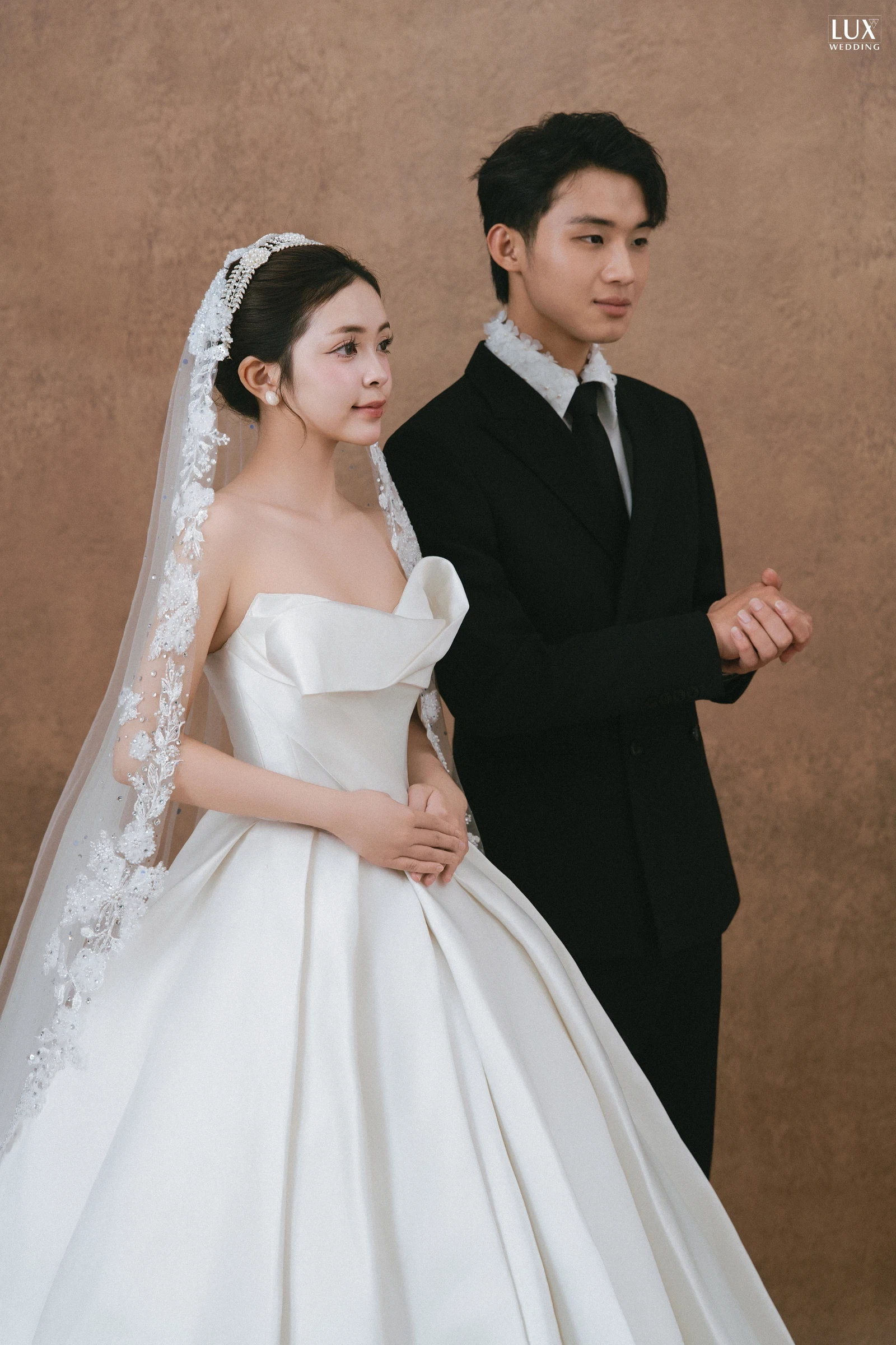 Cô dâu và chú rể trong ảnh cưới phông nâu