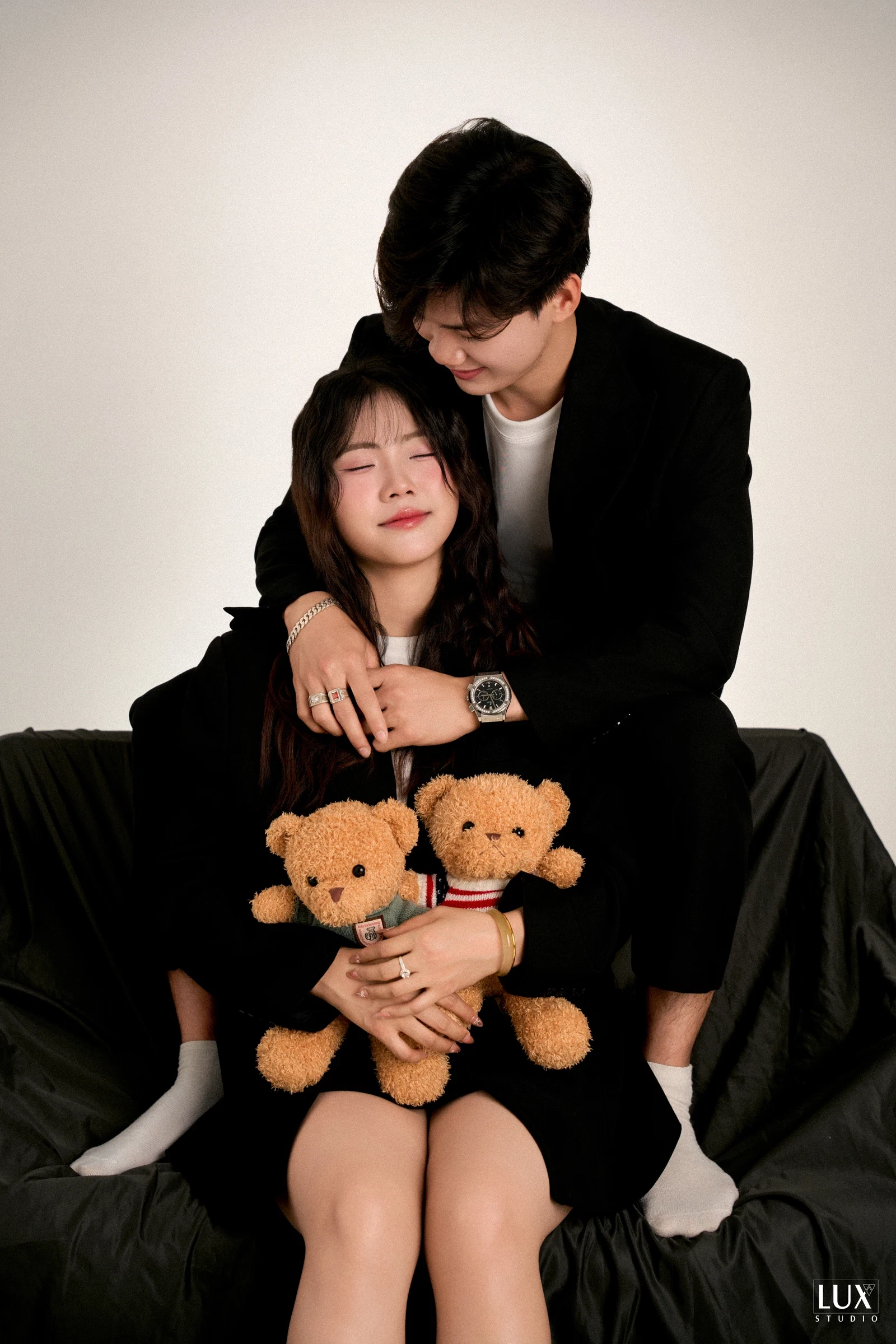 Cặp đôi ôm gấu bông trong studio nền trắng