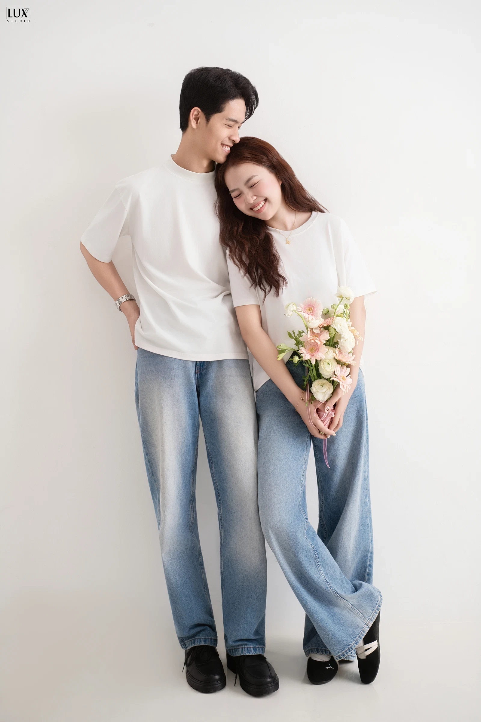 Cặp đôi áo trắng quần jeans tựa vào nhau