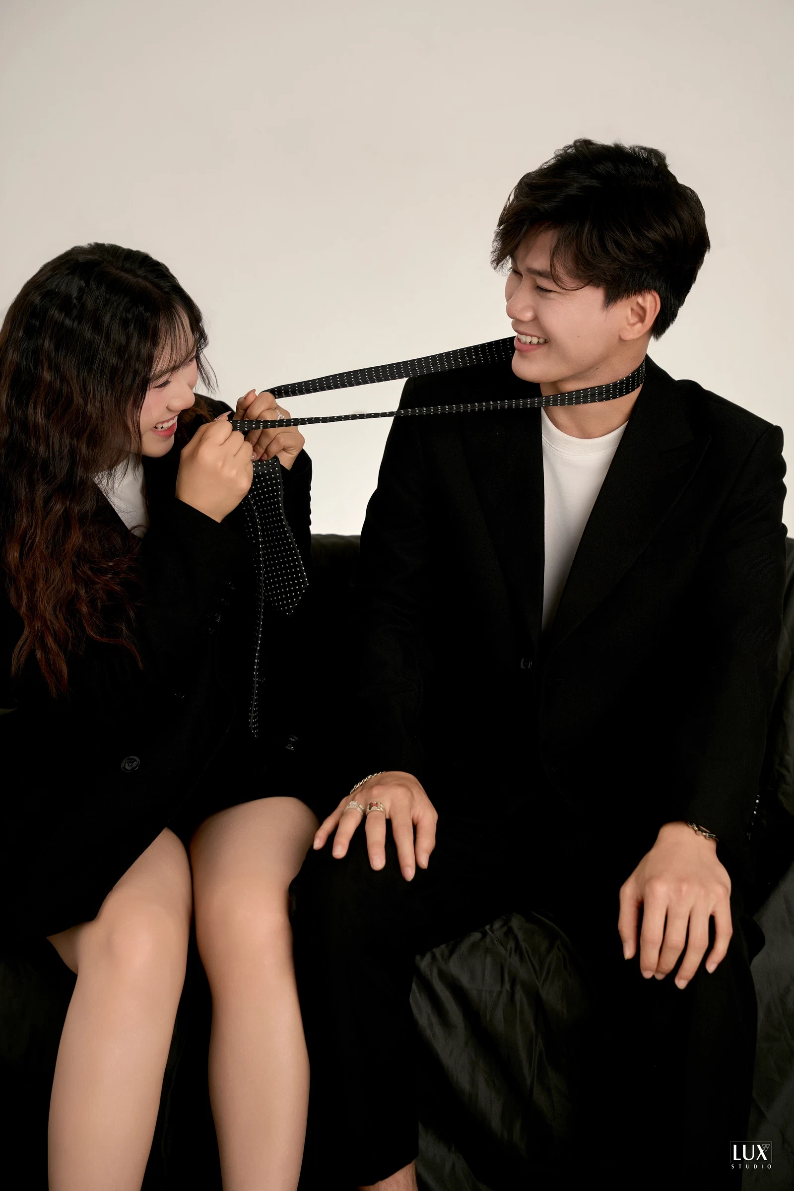 Cặp đôi áo đen ngồi cạnh nhau trong studio