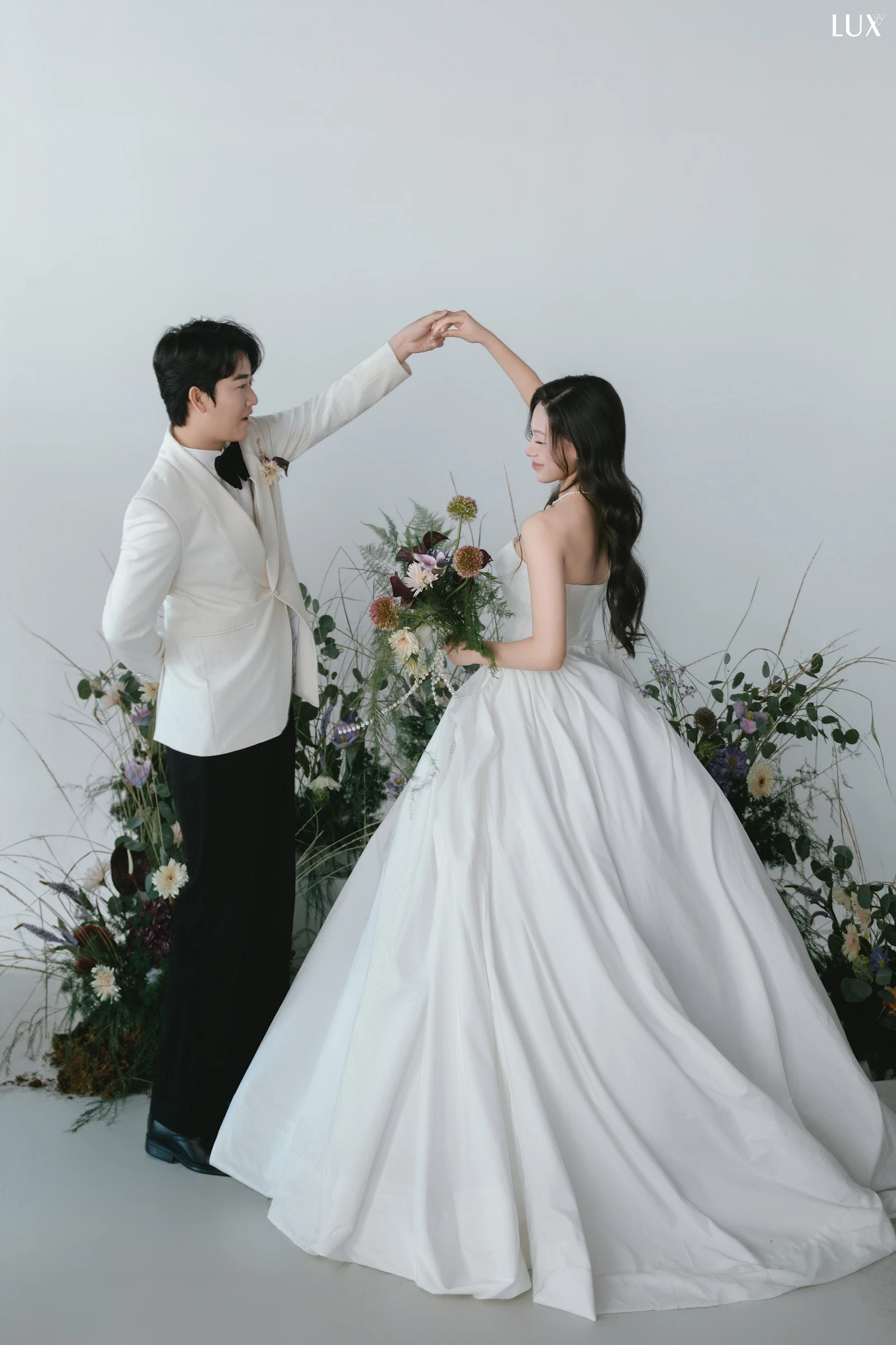 Cặp đôi đưa tay lên trong một tương tác trước ống kính, ảnh LUX Studio