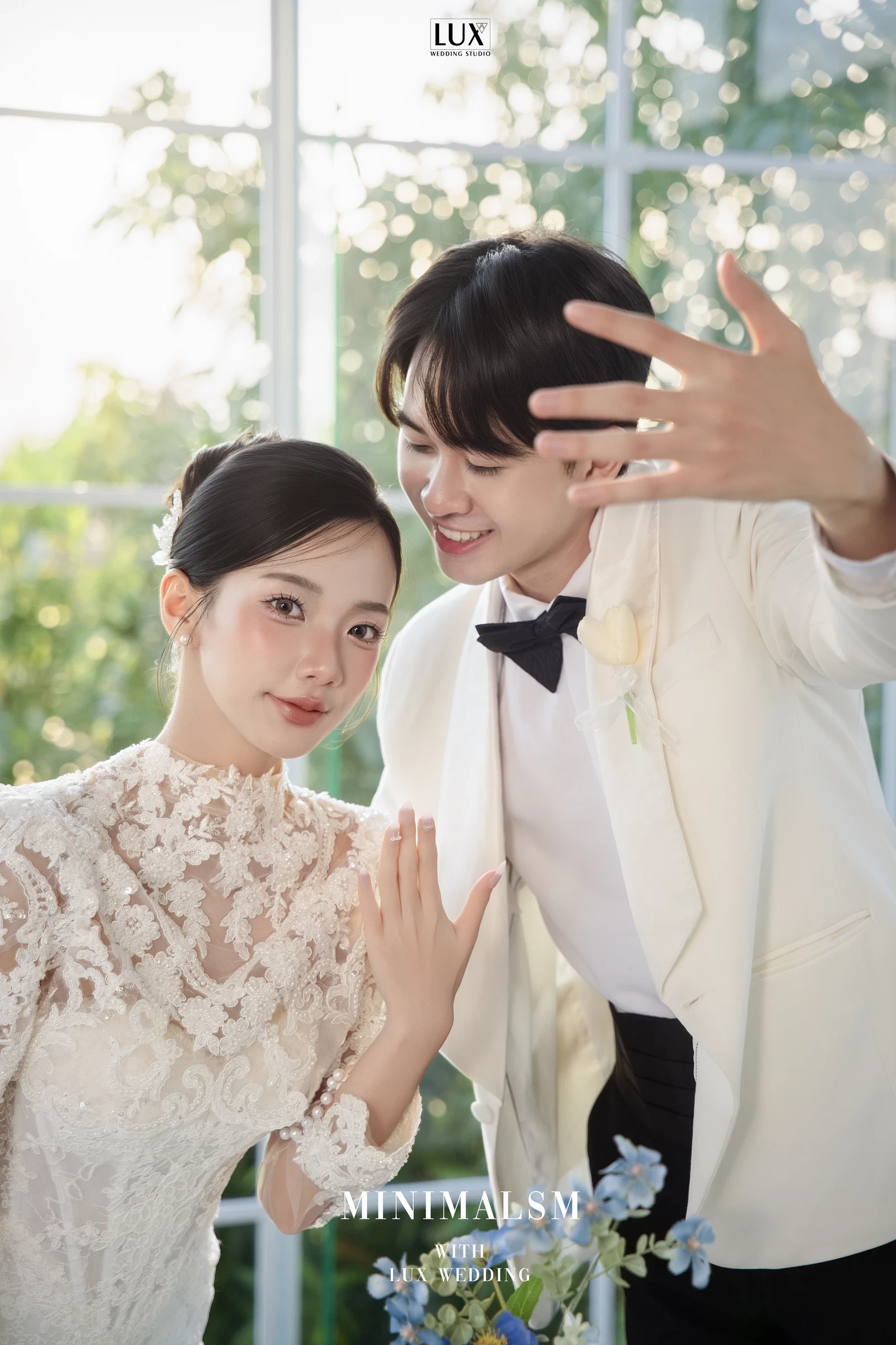 Cô dâu váy ren và chú rể vest trắng nhìn nhau
