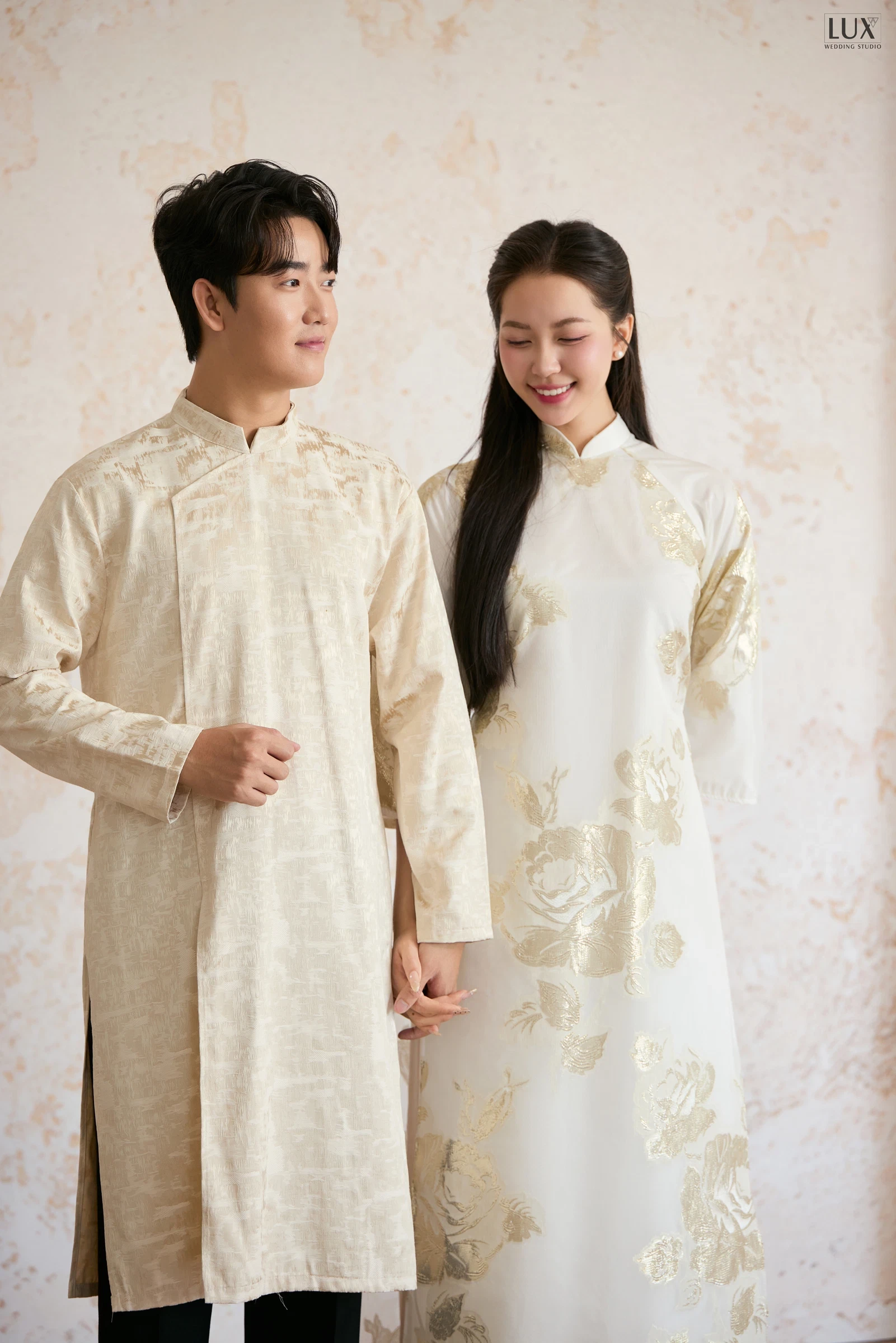 Cặp đôi áo dài kem thêu hoa trên phông sáng